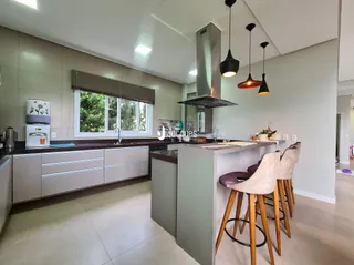 Vista da cozinha moderna com armários claros e bancadas escuras.