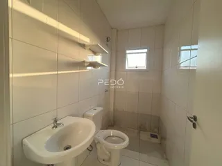 Foto de um banheiro com azulejos brancos e louças sanitárias.