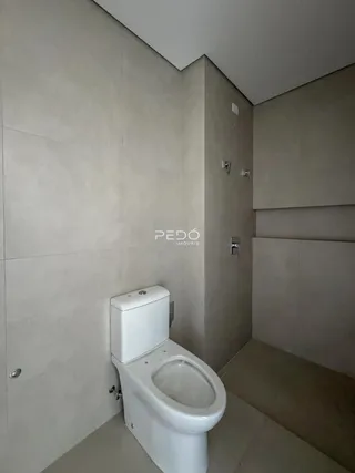 Foto de um banheiro com revestimento de cerâmica e vaso sanitário branco.