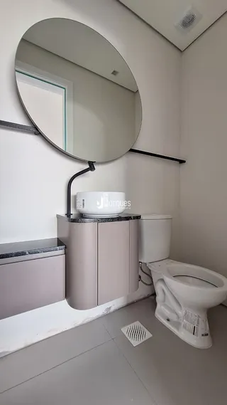 Foto de um banheiro moderno com espelho e vaso sanitário.