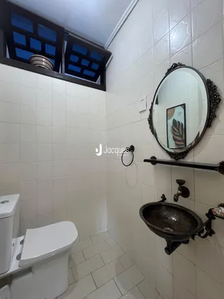 Banheiro com revestimento de cerâmica nas paredes e piso.
