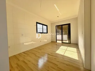Sala de estar com piso de madeira clara e paredes brancas.