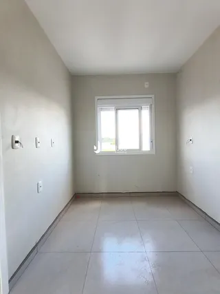 Vista de um corredor interno com piso de cerâmica e uma janela.