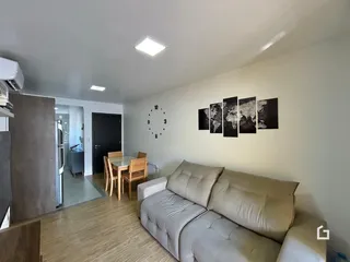 Sala de estar com sofá e mesa de jantar em uma residência.