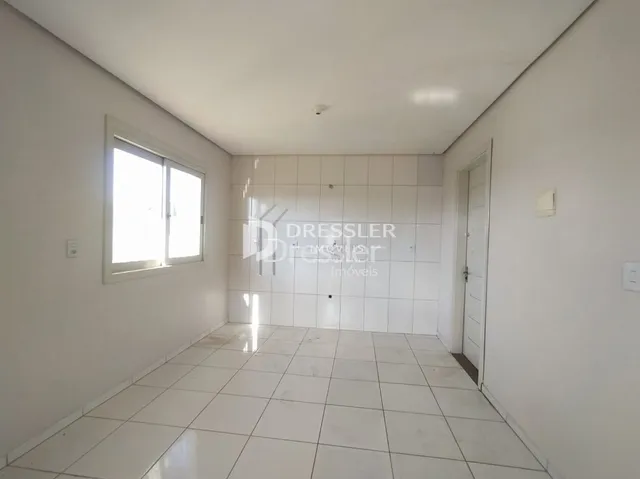 Corredor interno com piso de cerâmica e paredes brancas.