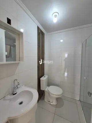 Foto de um banheiro com revestimento branco.