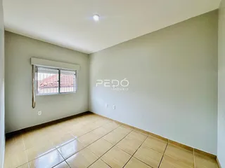 Sala de estar com piso de cerâmica clara e paredes neutras.