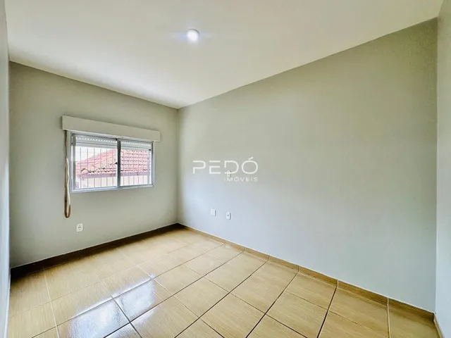 Sala de estar com piso de cerâmica clara e paredes neutras.