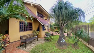 Fachada de uma casa em Lajeado, Brasil com jardim e banco de madeira.
