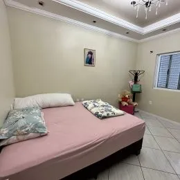 Quarto com cama e paredes claras em um imóvel.