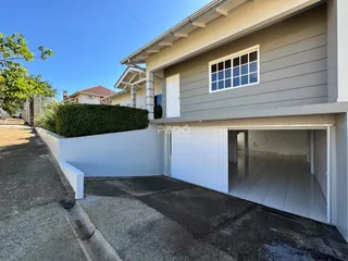 Fachada lateral de uma residência em Lajeado, Brasil, com garagem aberta.