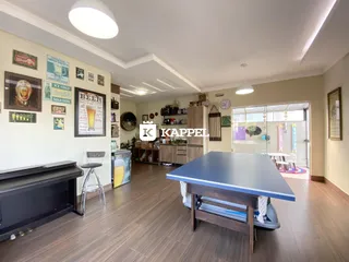 Uma sala de estar com uma mesa grande de madeira e decoração nas paredes.