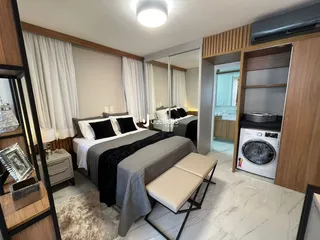 Quarto com cama e espelho em ambiente interno.