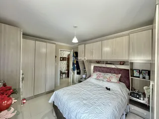Quarto com armários embutidos e cama grande em um imóvel no Brasil.