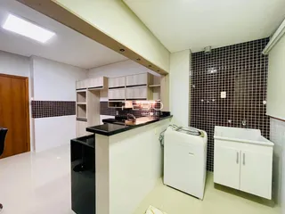 Vista interna de uma cozinha com armários e revestimento de azulejos.