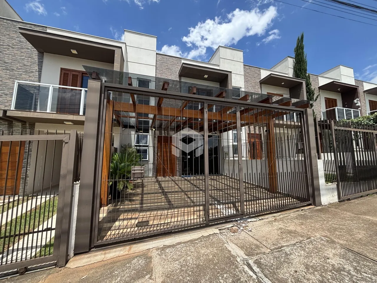 Foto da fachada de uma residência em Lajeado, Brasil, com portão de ferro.