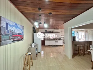 Cozinha moderna com armários brancos e piso claro.