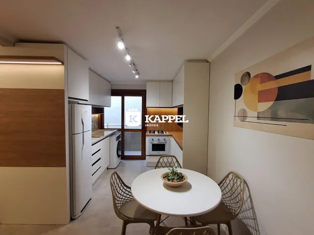Foto de uma sala de jantar com mesa redonda e cozinha moderna.