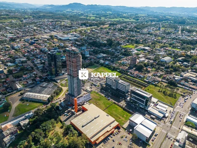 Vista aérea de uma área urbana com edifícios altos e paisagem ao fundo.