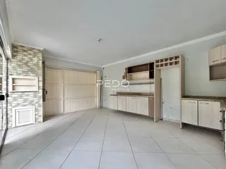 Sala de estar com piso de cerâmica clara e armários em madeira.