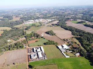 Vista aérea de uma propriedade rural com campos e estruturas no interior do Brasil.