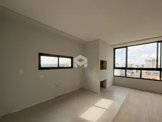 Interior de uma sala com paredes brancas e grande janela de vista para a cidade.