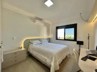 Quarto com cama grande e iluminação moderna.