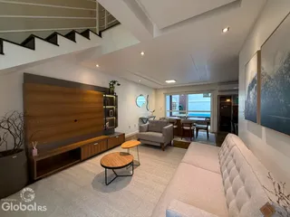 Sala de estar moderna com pé direito alto e decoração contemporânea.