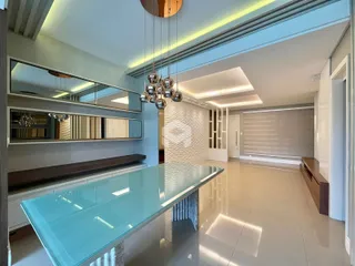 Ambiente interno moderno com mesa de vidro e iluminação embutida.