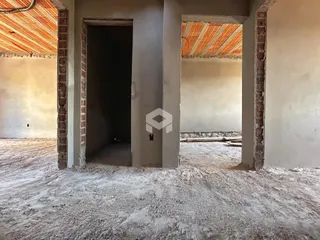 Foto de uma estrutura interna em construção com paredes de concreto aparente.