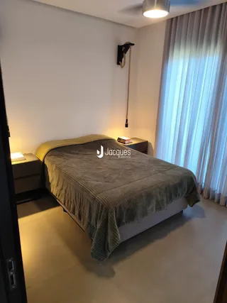 Quarto com cama e janela bem iluminada.