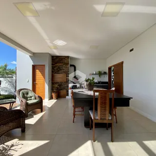 Ambiente interno de uma sala de estar com área de jantar e cozinha em Lajeado.