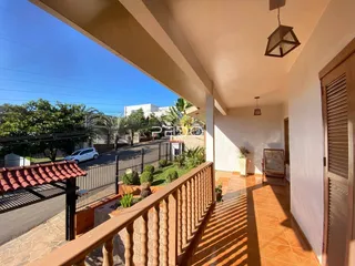 Vista de uma varanda com piso de cerâmica e grade de ferro.