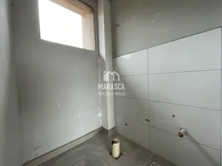 Vista interna de um corredor com parede branca e janela.