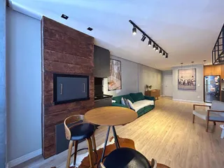 Sala de estar com decoração moderna e piso de madeira.