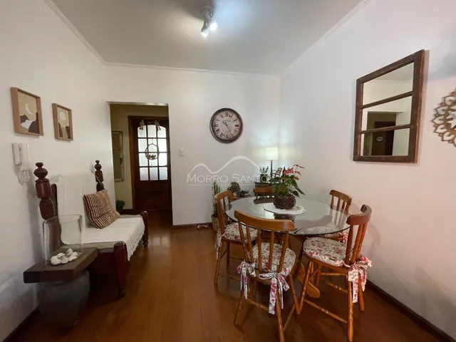 Sala de jantar com mesa redonda de vidro e cadeiras de madeira em um ambiente claro.