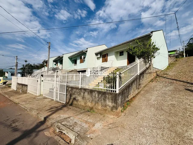 Vista da fachada de uma residência em Lajeado, Brasil, com cerca e muro.