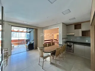 Sala de estar com vista para o exterior e cozinha integrada.