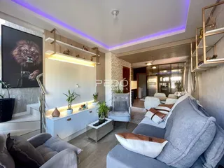 Sala de estar moderna com estantes e sofá em um apartamento no Brasil.