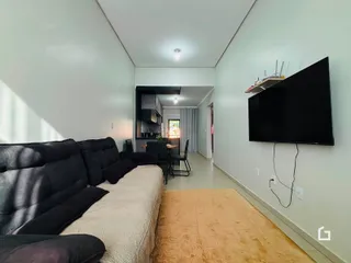 Sala de estar com sofá e televisão em um imóvel no Brasil.