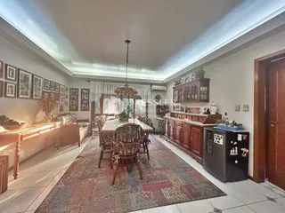 Sala de jantar com mesa de madeira e decoração de parede.