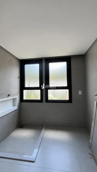 Vista interna de um ambiente com duas janelas grandes.