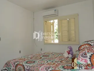 Quarto com cama e janela em ambiente interno.