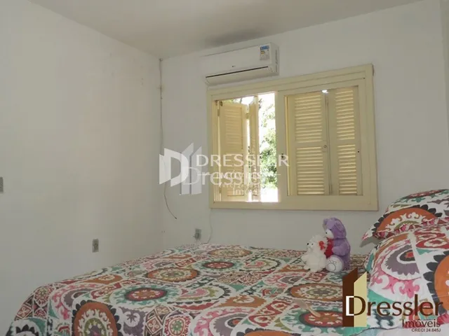 Quarto com cama e janela em ambiente interno.