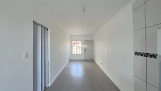 Corredor interno de uma residência com paredes brancas e piso claro.