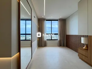 Sala de estar ampla com grandes janelas que oferecem uma vista urbana.