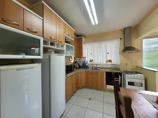 Foto de uma cozinha com armários de madeira e eletrodomésticos brancos.