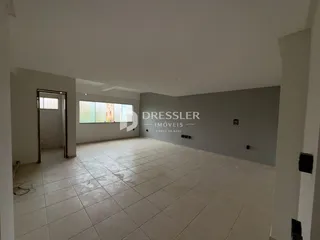 Interior de uma sala ampla com piso de cerâmica.