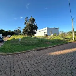 Vista externa de uma residência com paisagismo e área pavimentada.