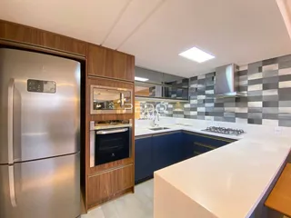 Cozinha moderna com armários de madeira e bancada branca.